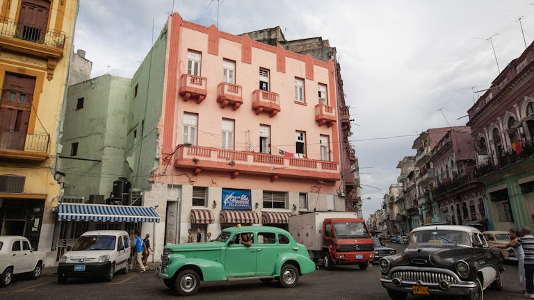 Photo of a 1950s era car parked along the roadside.