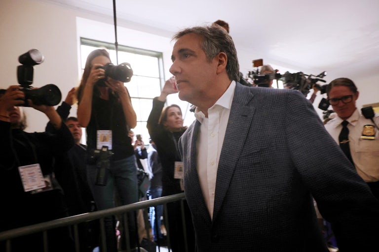 Michael Coen walks as photographers in the background capture photos of him