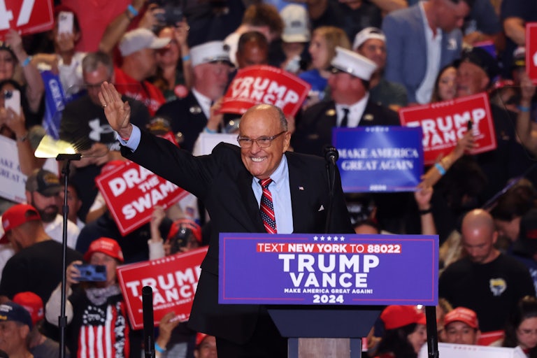Rudy Giuliani smiles and waves at a Donald Trump campaign rally