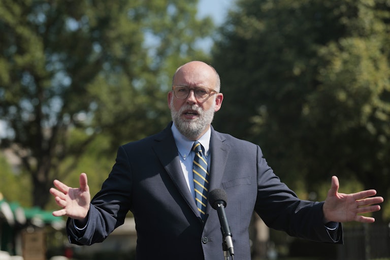 Russell Vought speaks otuside the White House, arms splayed outward