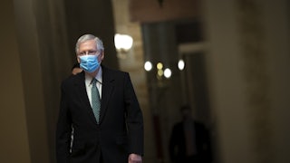 Minority Leader Mitch McConnell walks to the Senate Chamber wearing a mask.