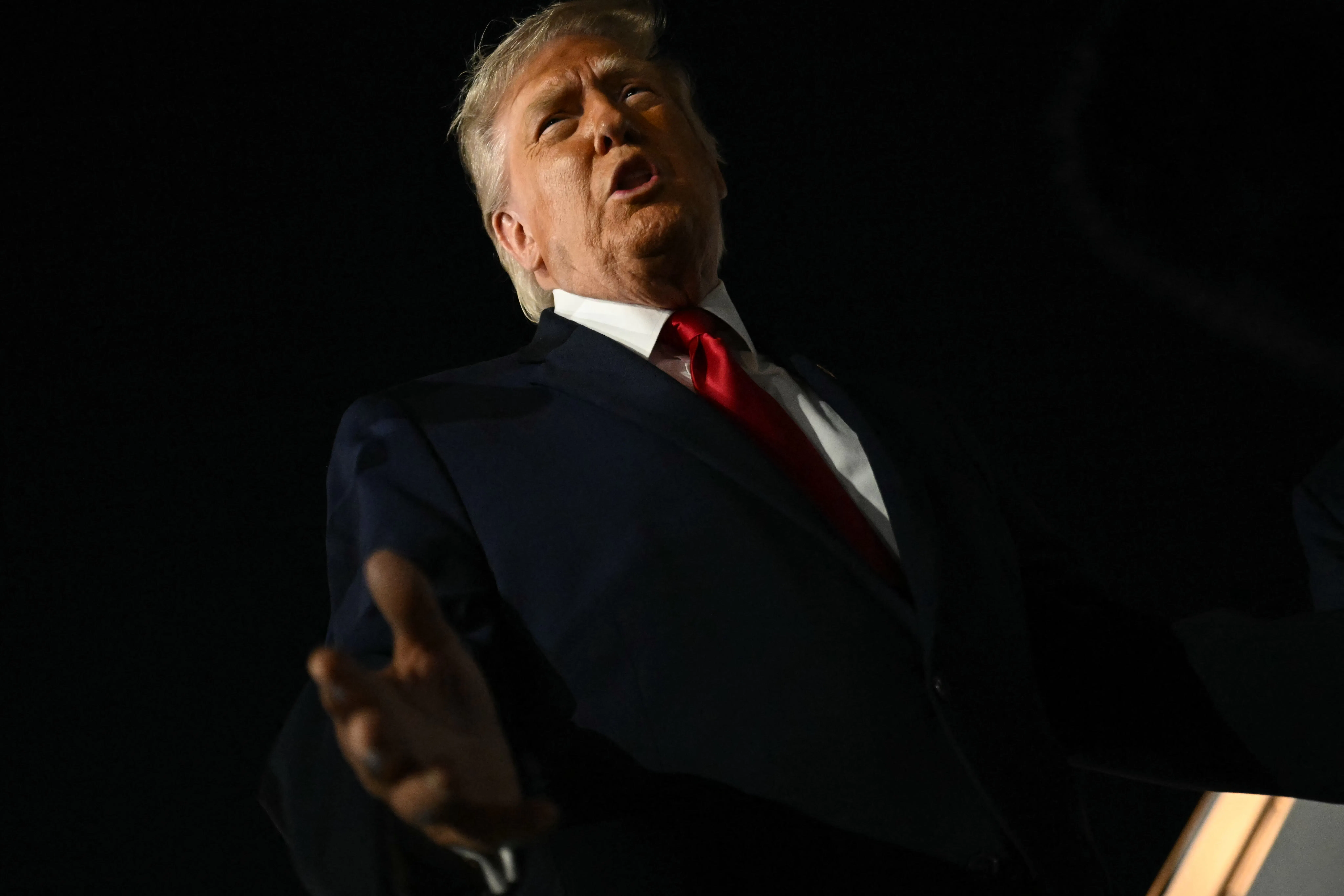 President Donald Trump speaks to reporters outside.