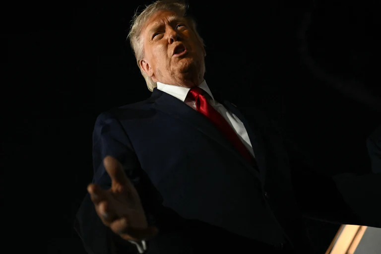 President Donald Trump speaks to reporters outside.