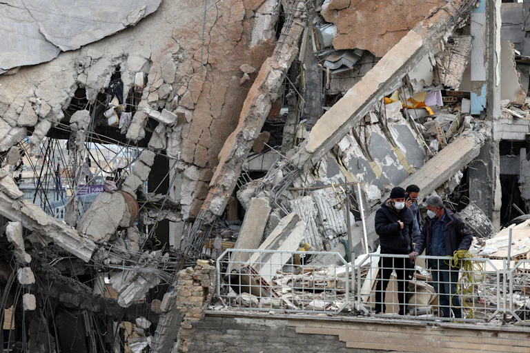 People stand amid rubble in Tehran