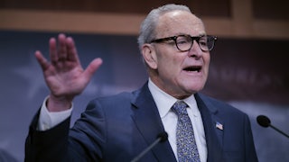 Senator Chuck Schumer gestures with one hand while speaking at a podium
