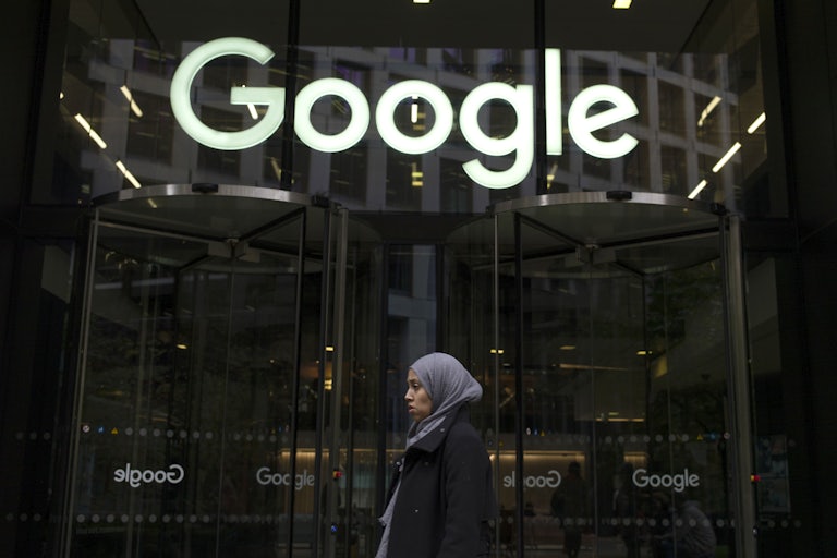 A woman walks past Google's headquarters in London, England