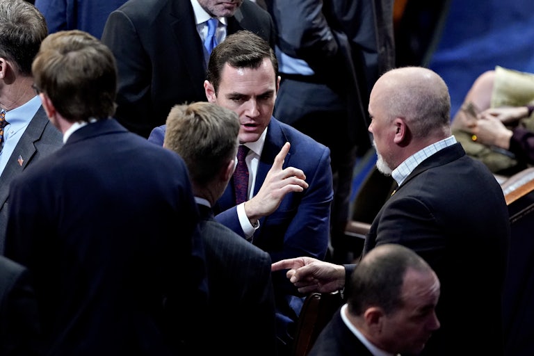 Mike Gallagher, Chip Roy, and others stand speaking to each other in the Capitol.