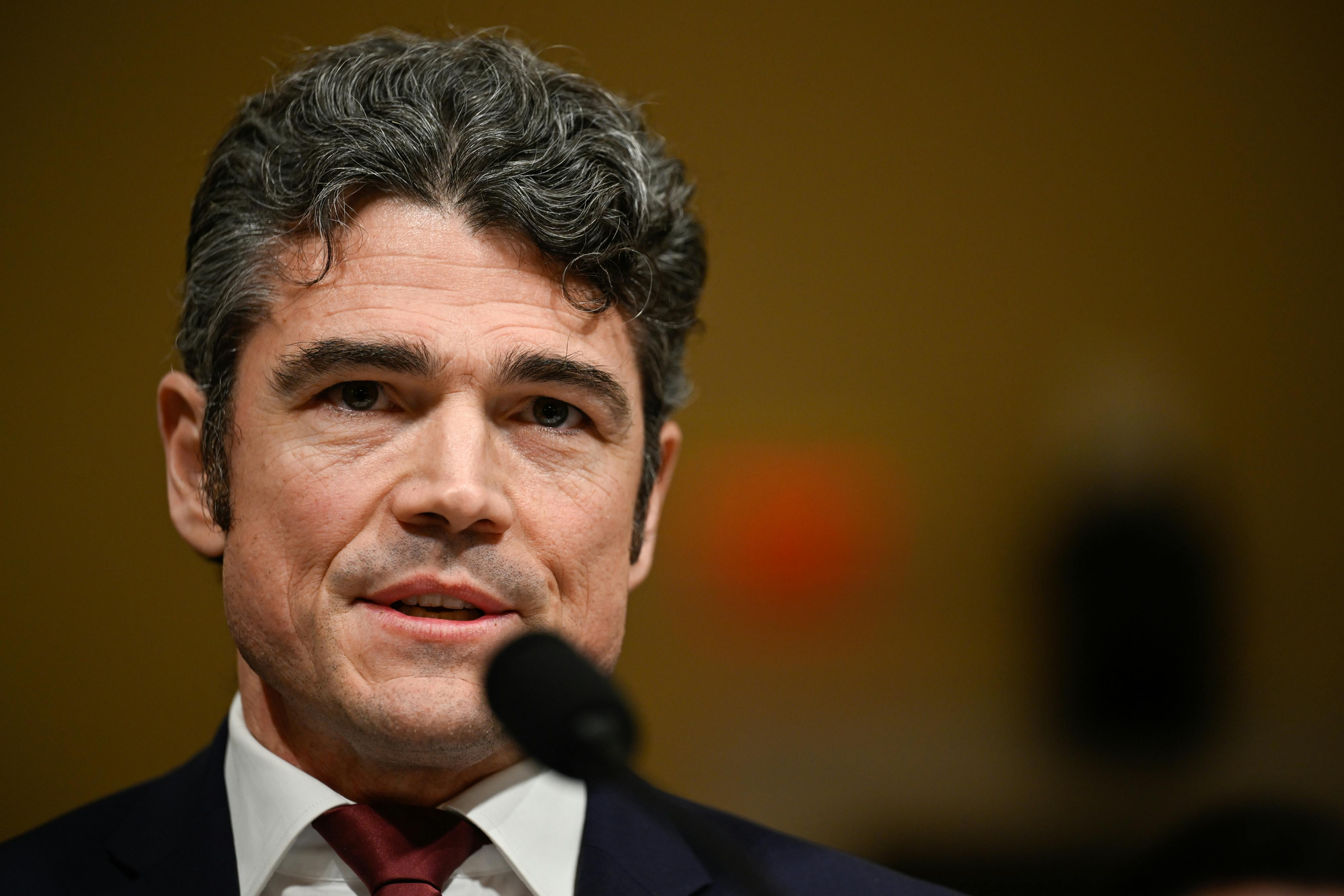 Joe Kent, the former director of the National Counterterrorism Center, speaks into a microphone.