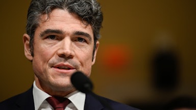 Joe Kent, the former director of the National Counterterrorism Center, speaks into a microphone.