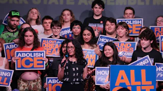 Democratic Congressional candidate Claire Valdez surrounded by supporters holding "Abolish ICE" signs