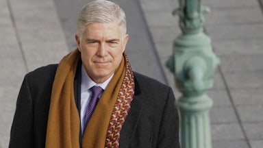 A close up of Justice Neil Gorsuch as he walks outside.