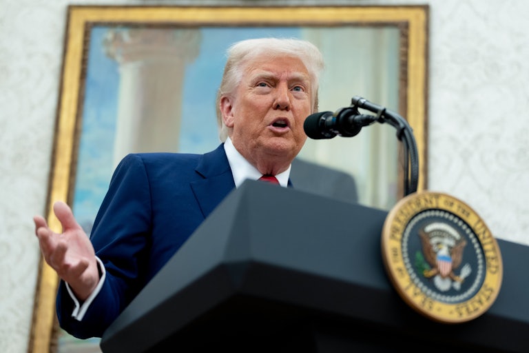 Donald Trump gestures while speaking at a podium in the Oval Office