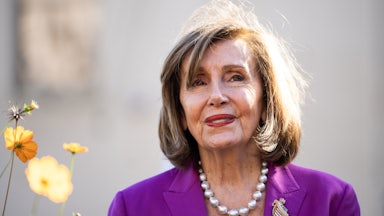 Former House Speaker Nancy Pelosi smiles while standing outside at an event
