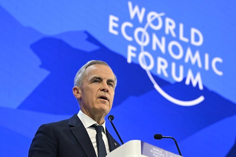 Canada’s Prime Minister Mark Carney delivers a speech at a podium in front of a blue backdrop that reads "World Economic Forum."