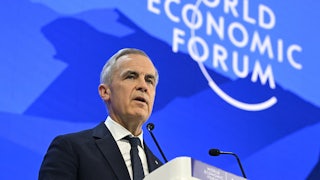 Canada’s Prime Minister Mark Carney delivers a speech at a podium in front of a blue backdrop that reads "World Economic Forum."
