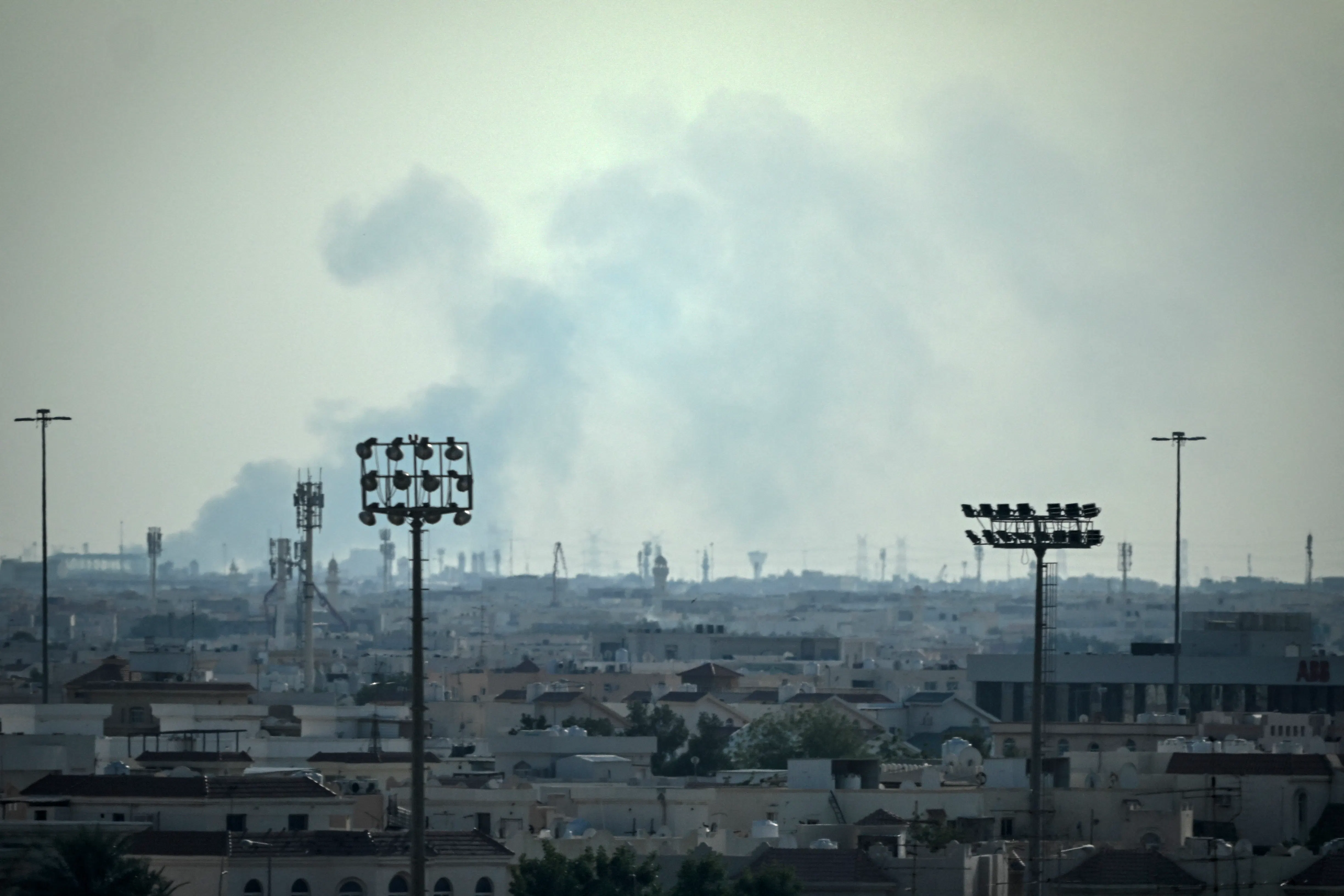 Smoke rises over the Doha, Qatar skyline near the Al Udeid Air Base.