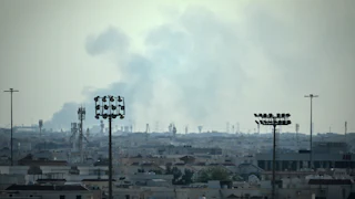 Smoke rises over the Doha, Qatar skyline near the Al Udeid Air Base.