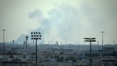 Smoke rises over the Doha, Qatar skyline near the Al Udeid Air Base.