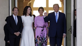 John Paulson, Alina de Almeida, Melania Trump, and Donald Trump smile and pose for photo in front of a pair of large open doors..