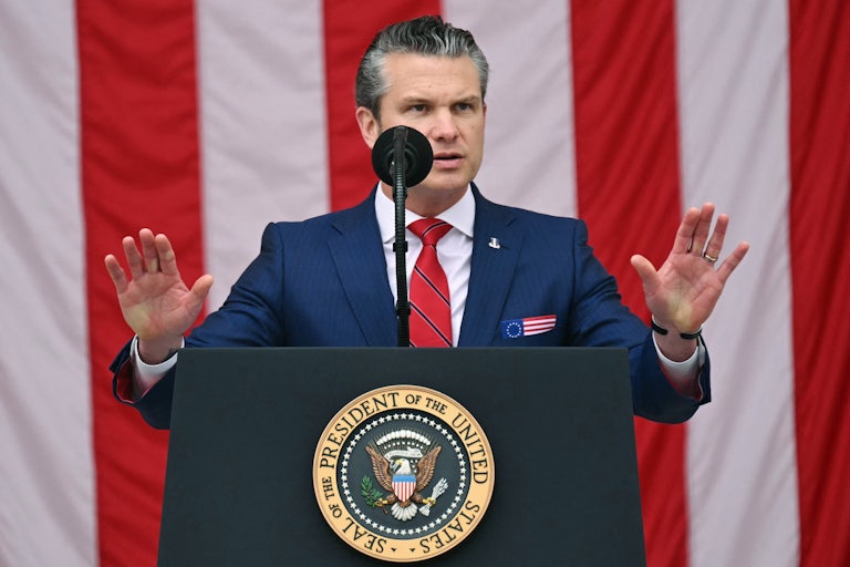 Pete Hegseth gestures while speaking at a podium during an event at Arlington National Cemetery