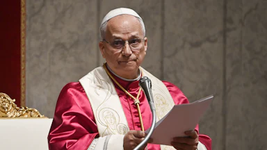 Pope Leo reads off a piece of paper as he delivers a speech