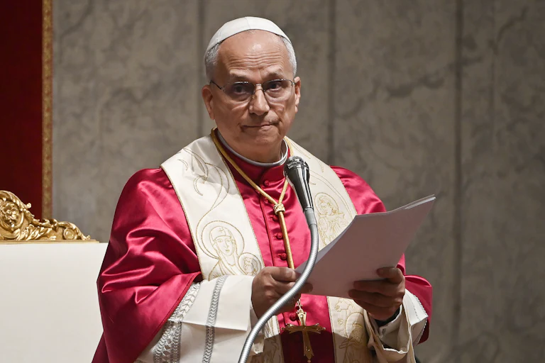 Pope Leo reads off a piece of paper as he delivers a speech