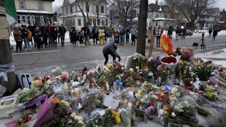 People stand around a memorial where Renee Good was shot in Minneapolis, Minnesota