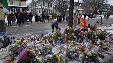 People stand around a memorial where Renee Good was shot in Minneapolis, Minnesota