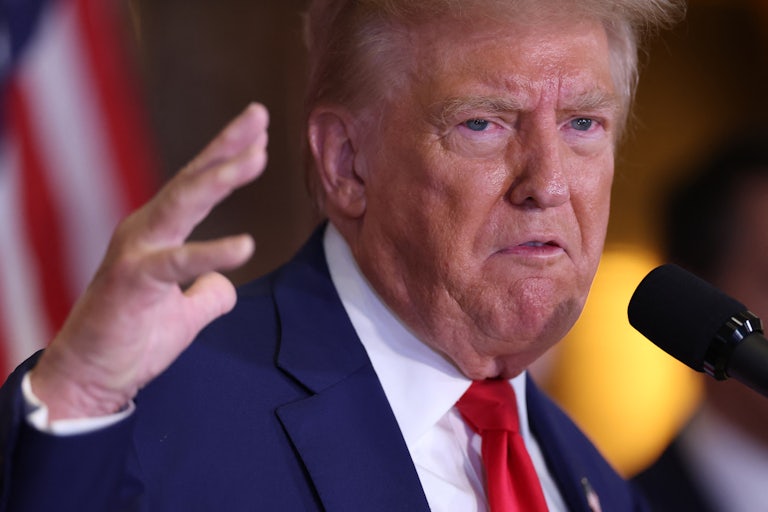 Donald Trump gestures while speaking into a microphone