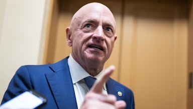 Senator Mark Kelly gestures while speaking to reporters in the Capitol