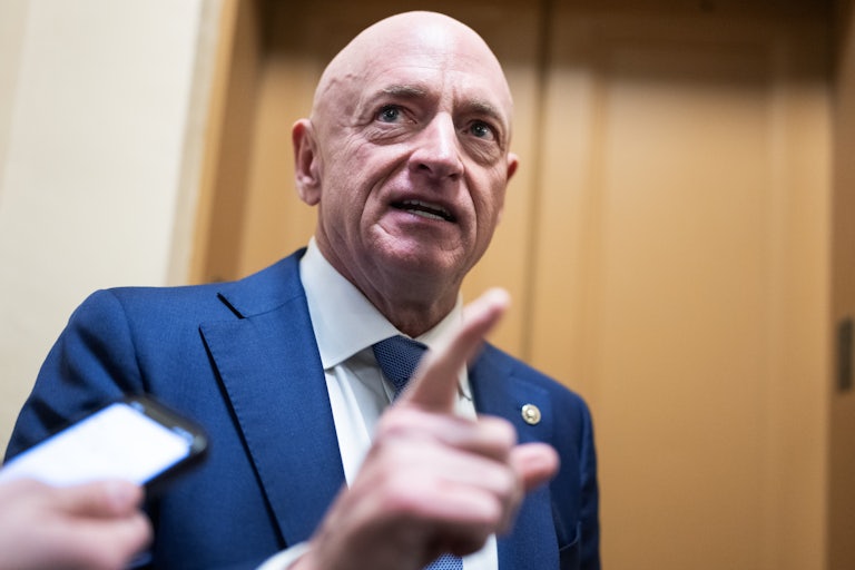 Senator Mark Kelly gestures while speaking to reporters in the Capitol