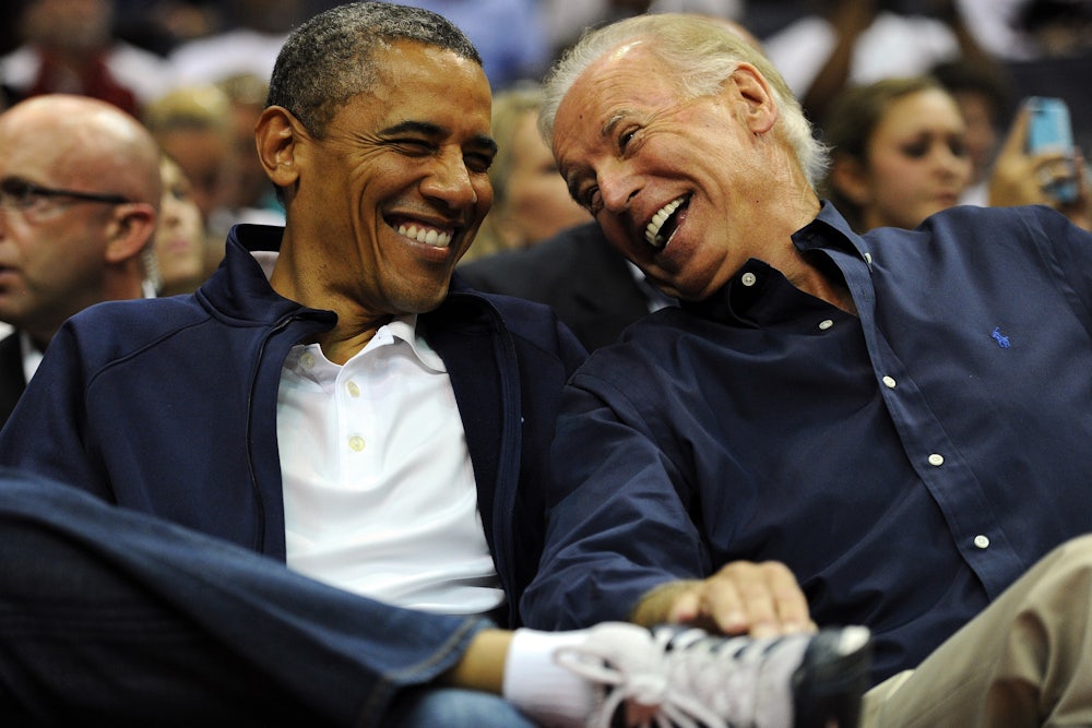 Joe Biden laughs and smiles as he looks at Barack Obama.