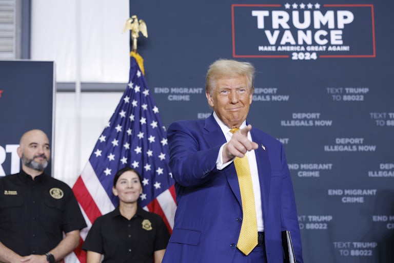 Donald Trump smiles and points during a campaign event