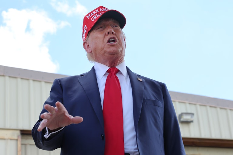 Donald Trump wearing a MAGA hat speaks animatedly