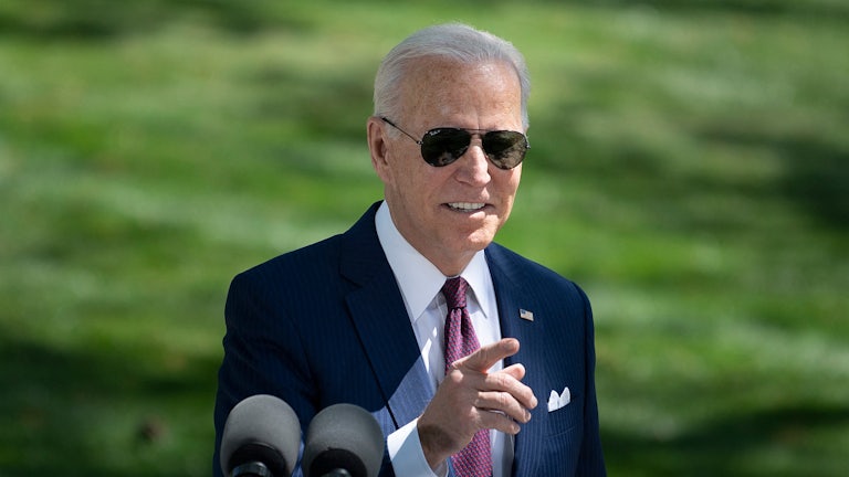 Joe Biden, wearing sunglasses, gestures.