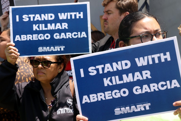 People hold up signs that say, "I stand with Kilmar Abrego García" in a protest calling for his return to the U.S.