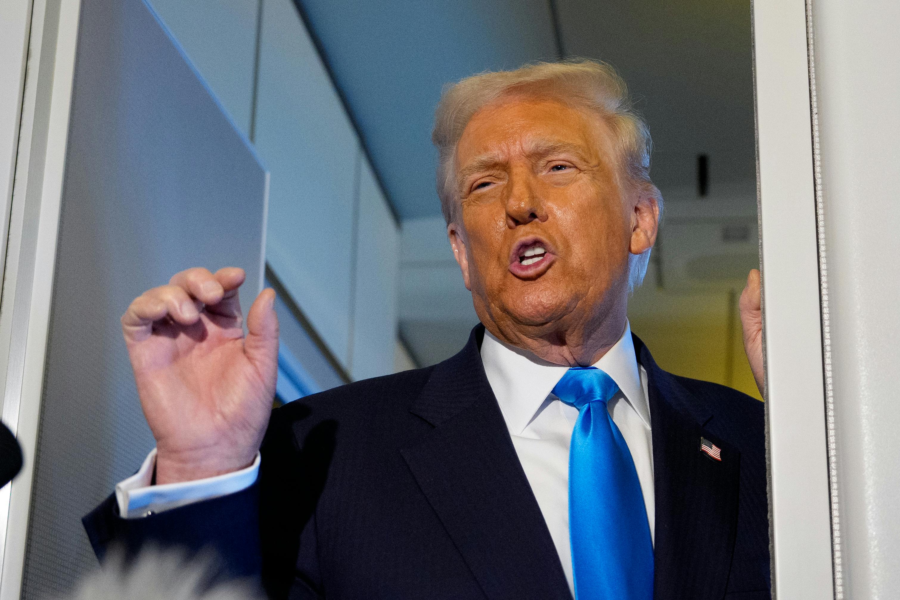 Donald Trump speaks angrily while making a hand gesture aboard Air Force One.