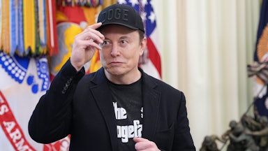 Elon Musk wears a DOGE cap and a shirt that reads "The Dogefather," in the same font as The Godfather movies.