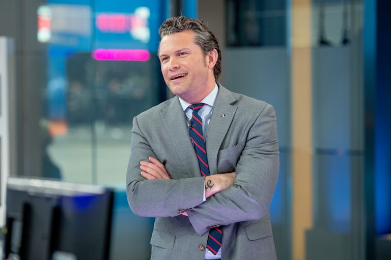 Fox & Friends host Pete Hegseth crosses his arms during a broadcast.