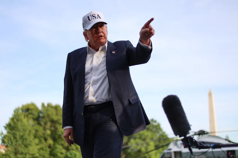 Donald Trump points while walking outside the White House