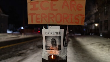 A sign that says "ICE are terrorist" hangs above a photo of Renee Good, who was shot dead by ICE in Minneapolis, Minnesota. The photo says, "RIP Renee. Murdered by ICE"