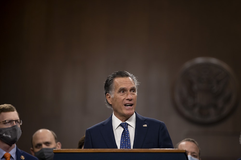Senator Mitt Romney speaks to a group of masked members of Congress at the Capitol