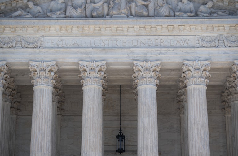 A close-up of the facade of the Supreme Court, where the words "Equal Justice Under Law" are etched.
