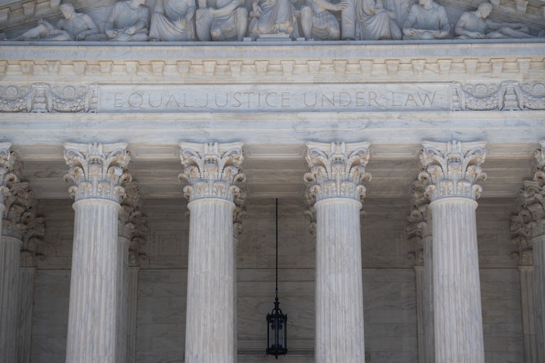 A close-up of the facade of the Supreme Court, where the words "Equal Justice Under Law" are etched.