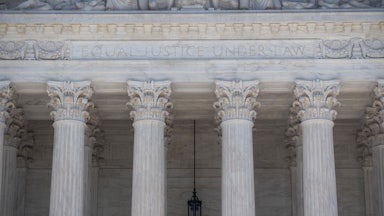 A close-up of the facade of the Supreme Court, where the words "Equal Justice Under Law" are etched.