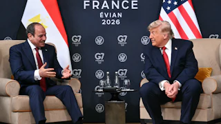 Egypt’s President Abdel Fattah El-Sisi and U.S. President Donald Trump sit on two armchairs as they smile at each other.