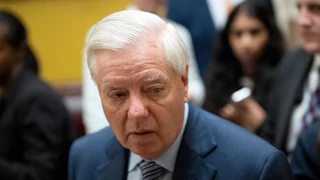 Senator Lindsey Graham looks to the side while walking in the Capitol