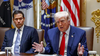Donald Trump gestures and speaks while sitting next to Secretary of State Marco Rubio at a conference table