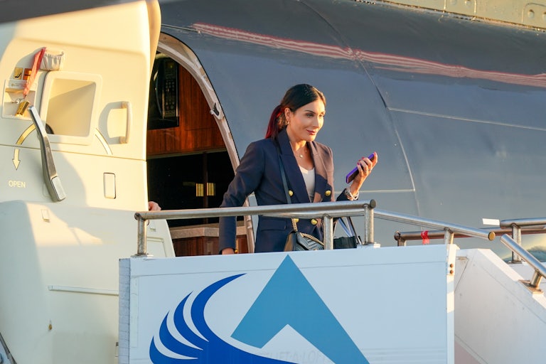 Laura Loomer holds her cell phone while disembarking from Donald Trump’s private jet