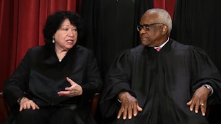 Supreme Court associate Justices Sonia Sotomayor and Clarence Thomas sit next to each other.